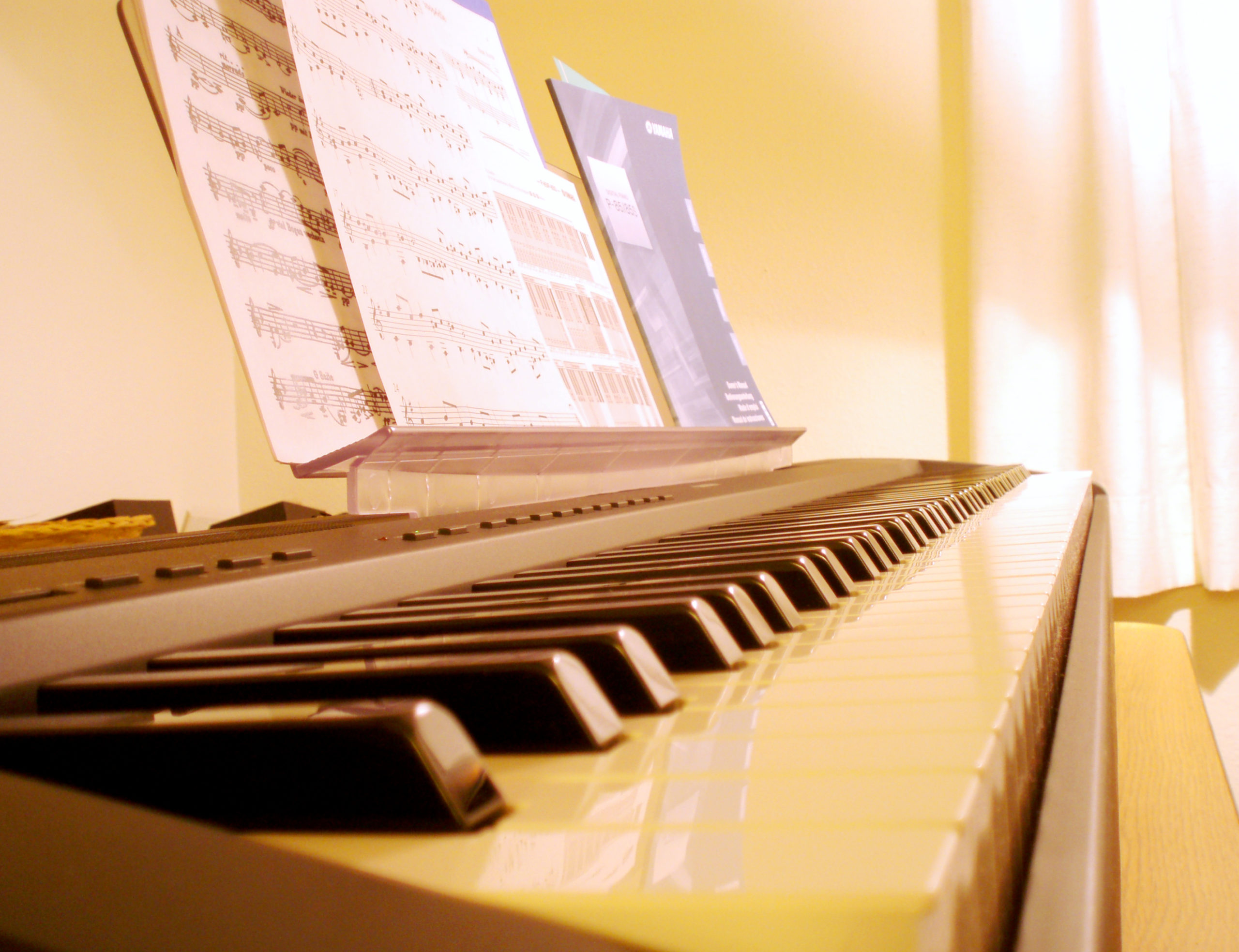 Бумажные ноты на пюпитре цифрового пианино Yamaha P-85